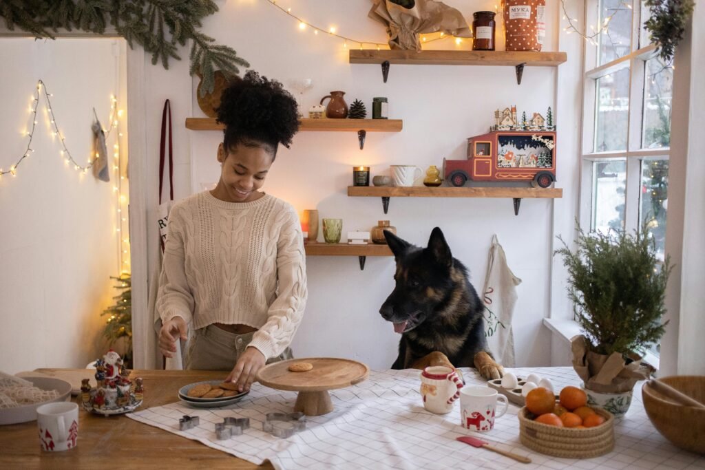 pexels-photo-6606712-6606712 A joyful woman baking cookies with her German Shepherd in a festively decorated kitchen.