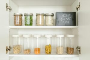 pexels-photo-8580793-8580793 Neatly arranged glass and plastic jars containing grains and pasta in a kitchen cabinet.
